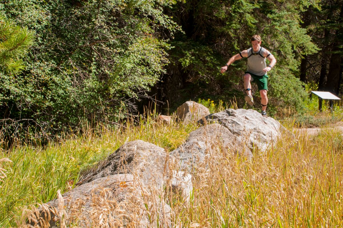 Runner crossing a rocky trail outdoors